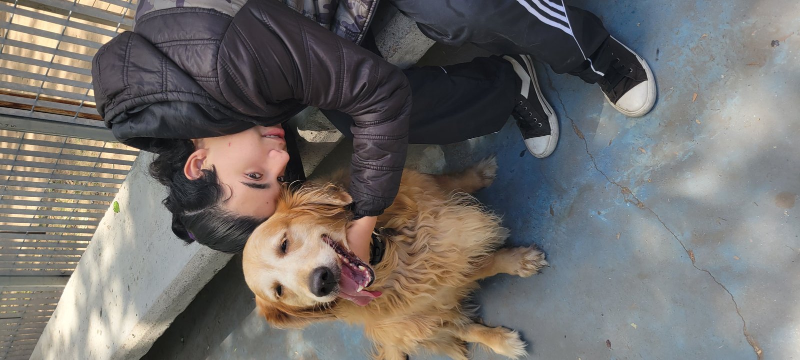 Un joven abrazando a un perro al aire libre